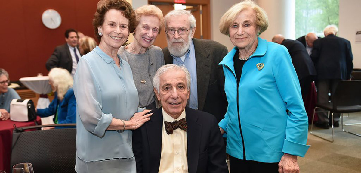 Carl Felsenfeld sits photographed, surrounded by four family members