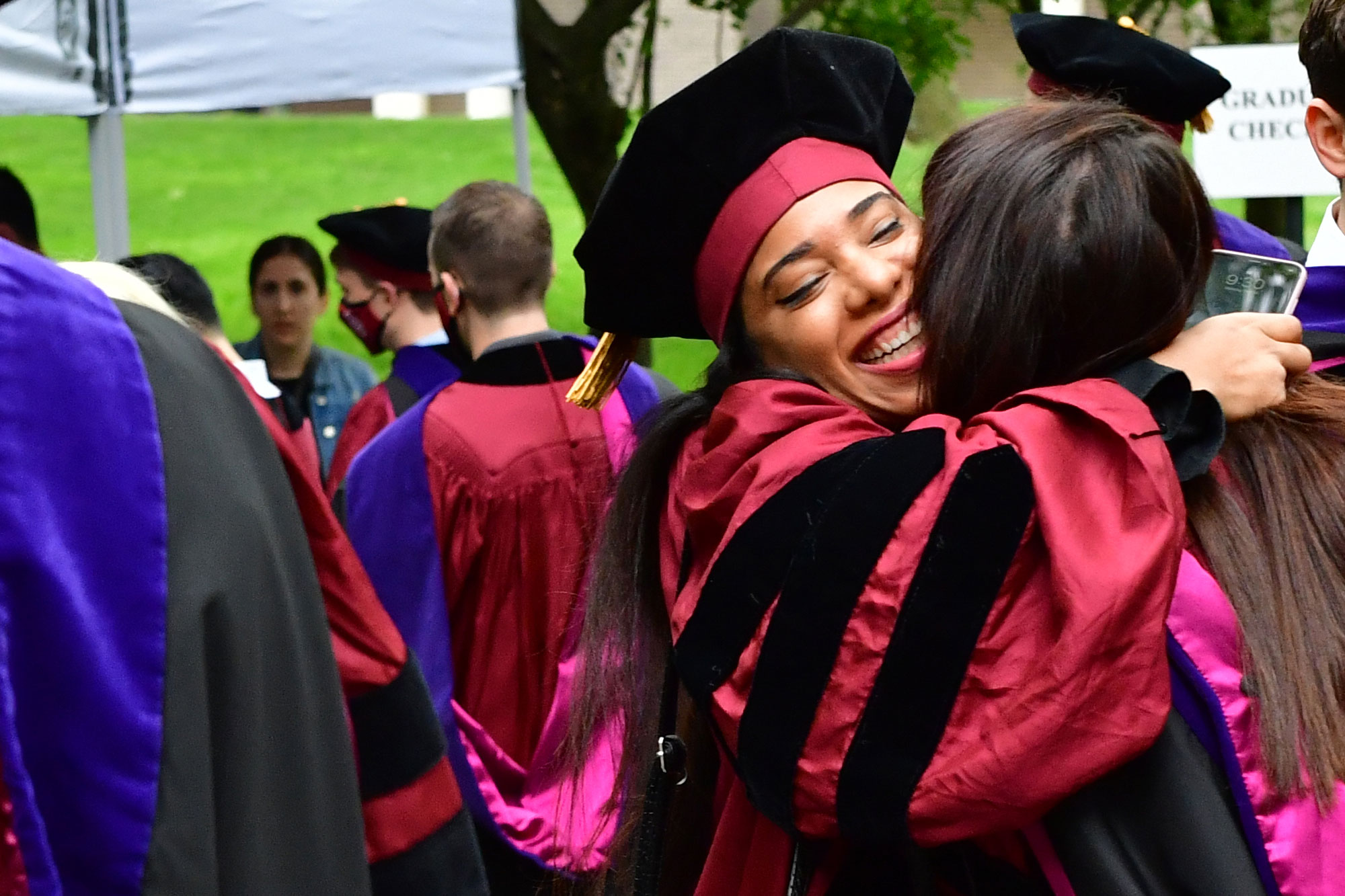 students hugging at graduation