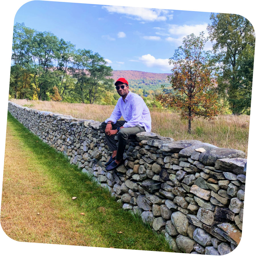 Jordan Adams sitting on stacked stone wall
