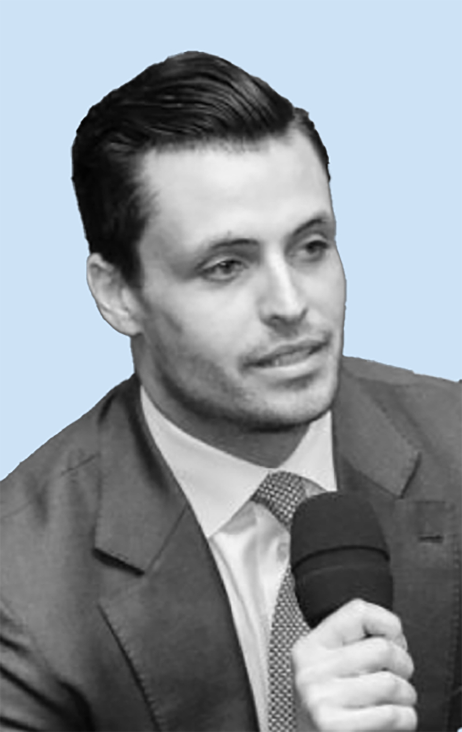 A black and white close-up portrait photograph perspective of Shaoul Sussman speaking while holding a microphone