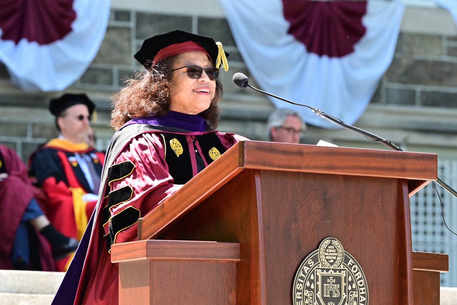 a member of faculty speaking at the podium during the 115th Diploma Ceremony