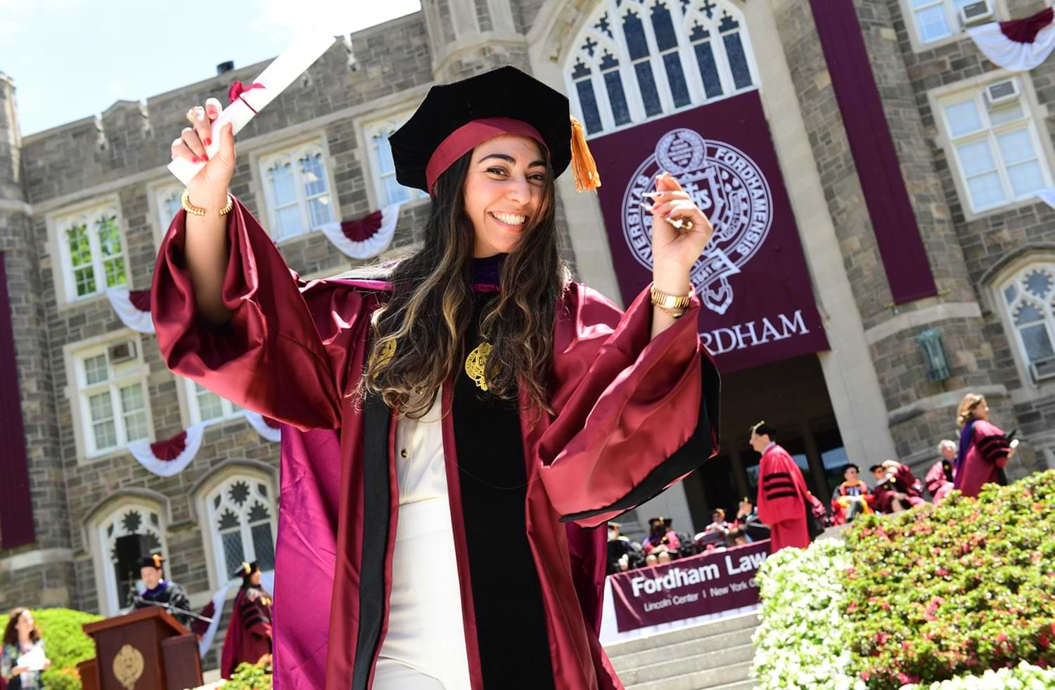 a graduate celebrates on the walkway