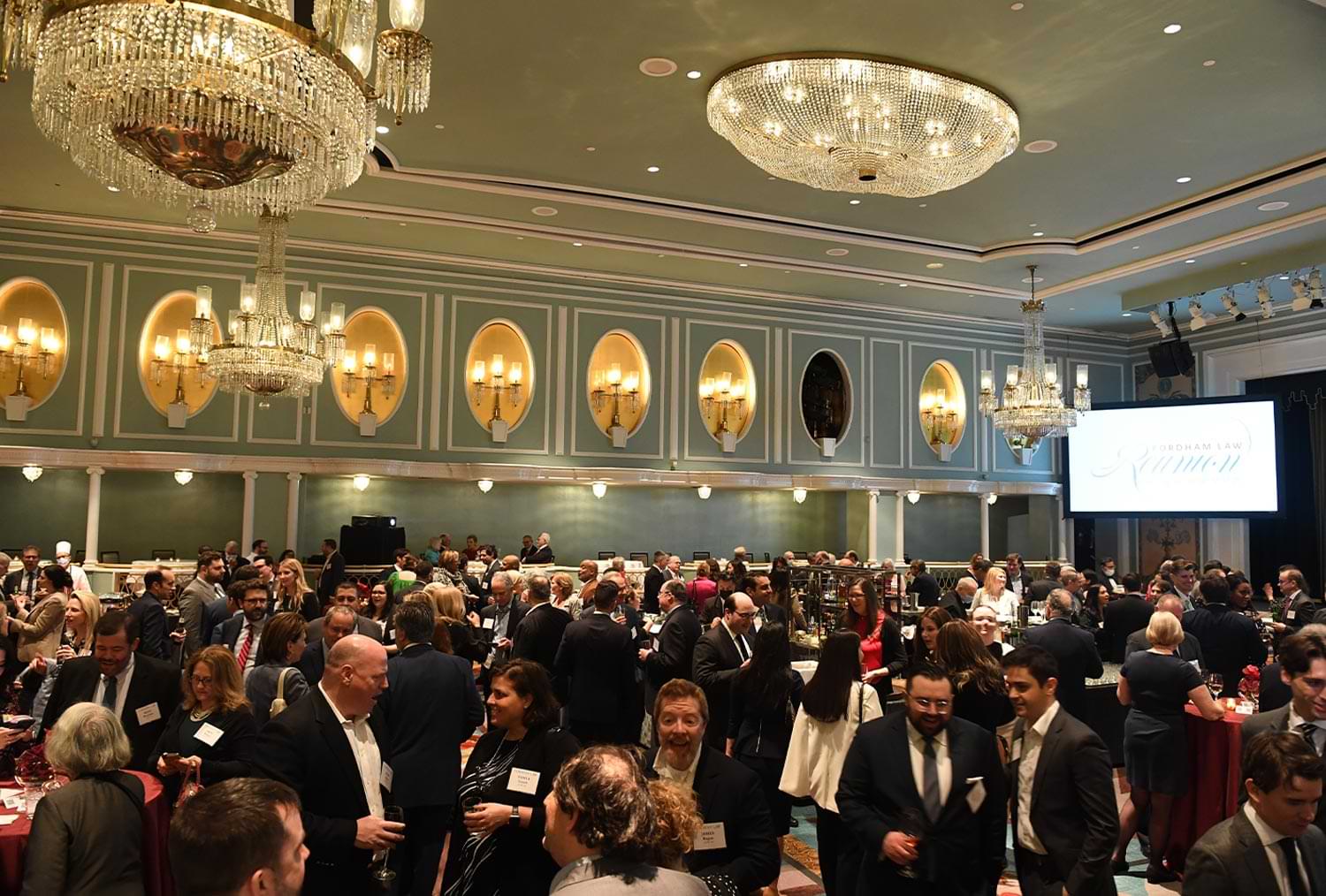 wide view of a large banquet room full of alumni and event attendees