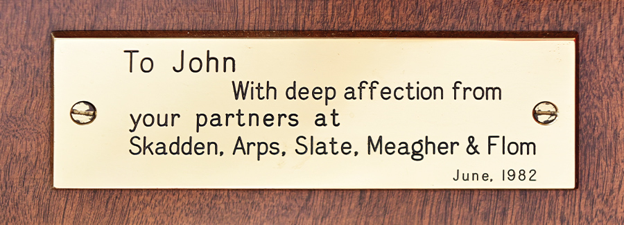 Sign that says "To John, With deep affection from your partners at Skadden, Arps, Slate, Meagher & Flom June 1982"