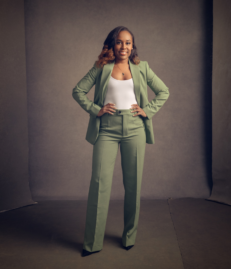 Sharde Simpson posing with hand on her hips while wearing a light green pantsuit 