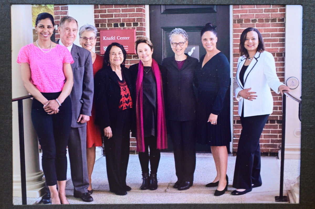 group photo of people standing in front of brick building