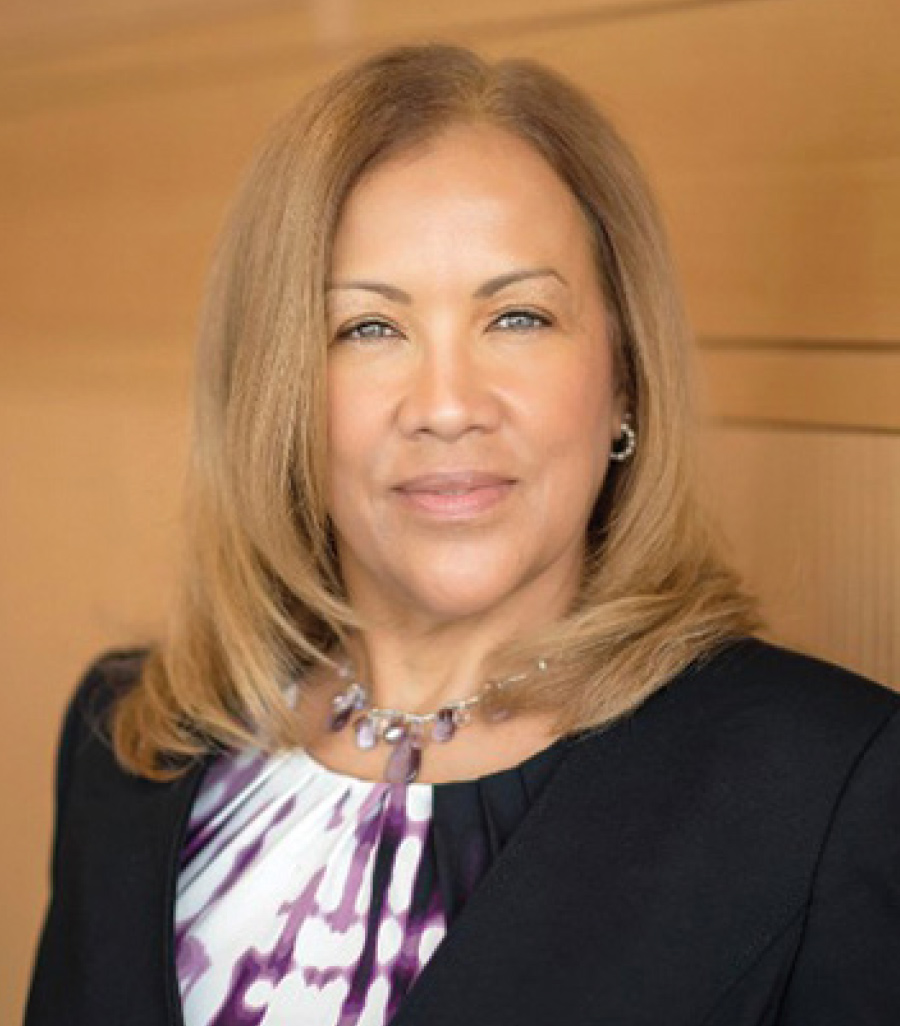 Headshot of Brenda L. Gill grinning in a black business blazer suit