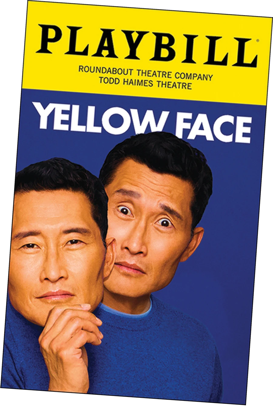 Playbill cover for the play "Yellow Face" at Todd Haimes Theatre. Actor Daniel Dae Kim holds a stoic mask of his own face, peering out from behind it with a surprised expression against a blue background.